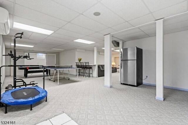 workout room with a wall mounted air conditioner, baseboards, and a drop ceiling