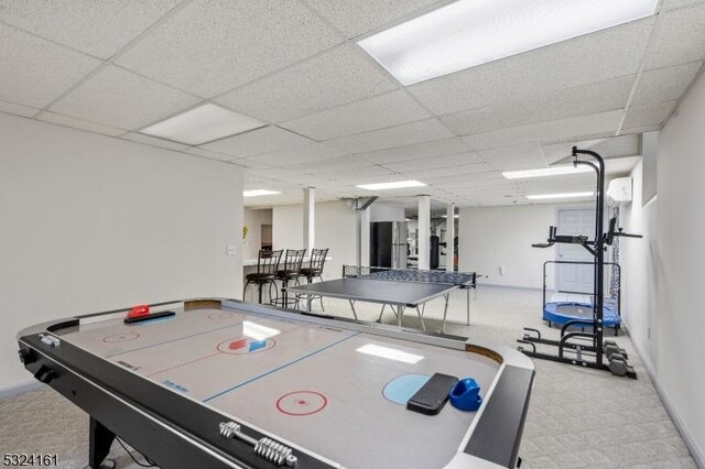 recreation room featuring a paneled ceiling and baseboards