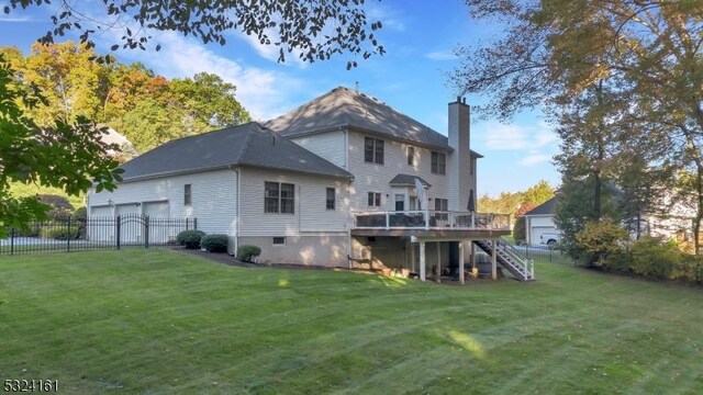 back of property with a lawn, stairs, a deck, and fence