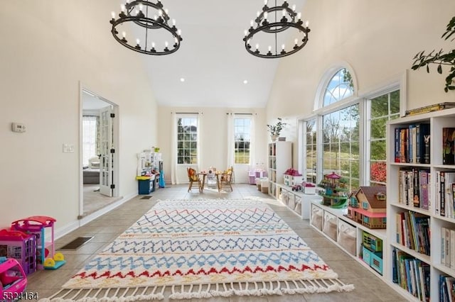 playroom featuring an inviting chandelier and high vaulted ceiling