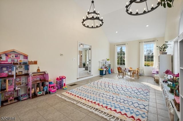 game room featuring light tile patterned flooring, high vaulted ceiling, and an inviting chandelier