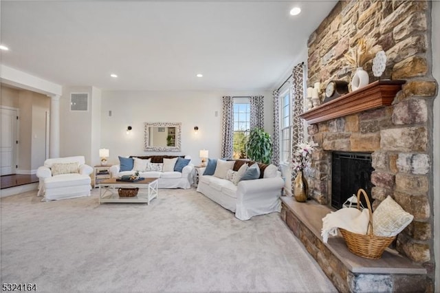 living room featuring decorative columns, light colored carpet, and a fireplace