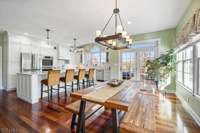 dining room with dark wood-type flooring and a chandelier