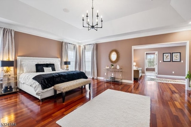 bedroom with dark hardwood / wood-style floors, a raised ceiling, and a notable chandelier