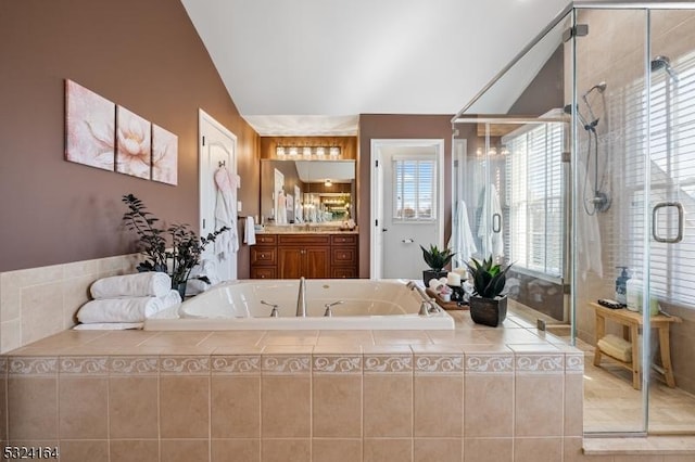 bathroom featuring vanity, independent shower and bath, and vaulted ceiling