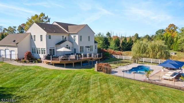 rear view of property with a lawn and a swimming pool side deck