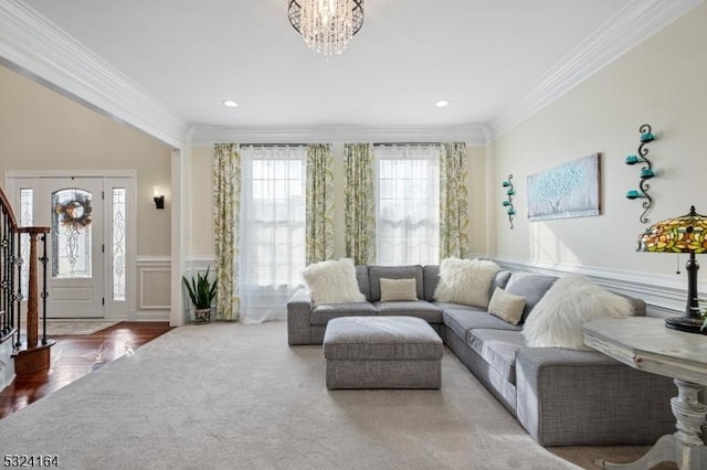 living room with crown molding and a chandelier