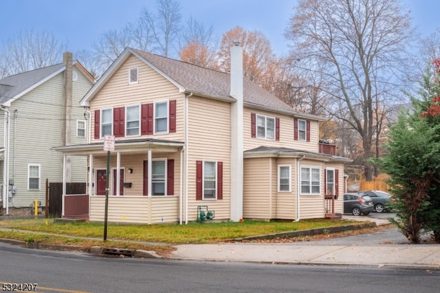 view of front facade featuring covered porch and a front yard