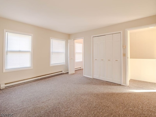 unfurnished bedroom featuring carpet floors, a baseboard radiator, and a closet