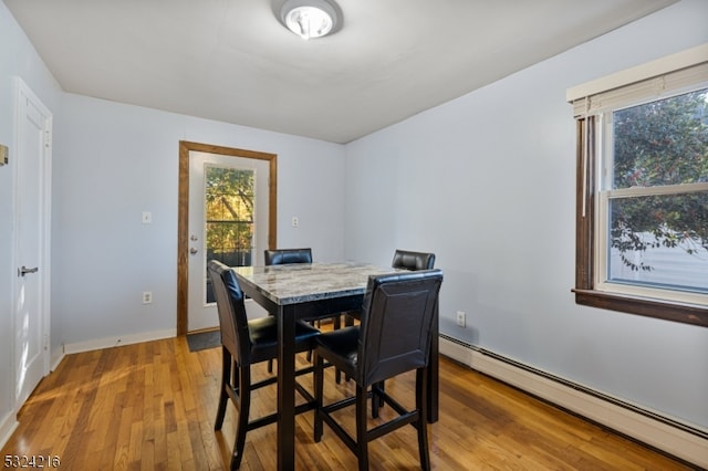 dining space featuring a baseboard heating unit and light hardwood / wood-style flooring