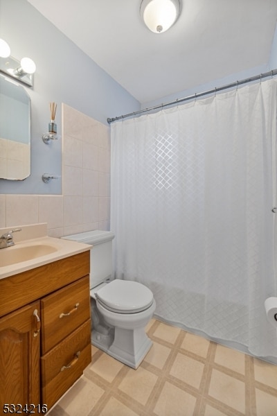 bathroom featuring toilet, vanity, tile walls, and a shower with shower curtain