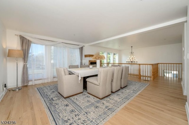 dining area featuring light wood-style floors and an inviting chandelier