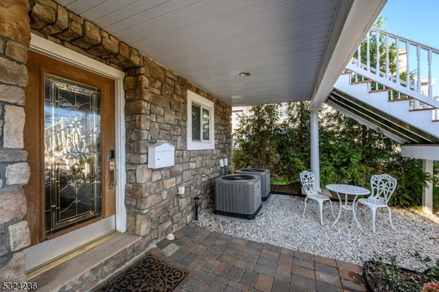 view of patio featuring central AC unit and stairs