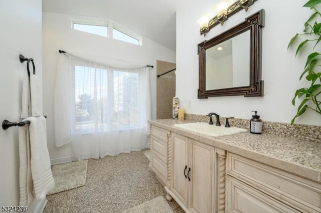 full bathroom featuring vanity and lofted ceiling