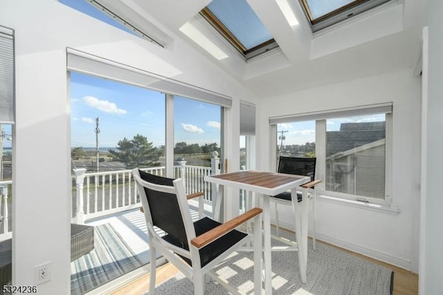 sunroom with beam ceiling, coffered ceiling, and a skylight