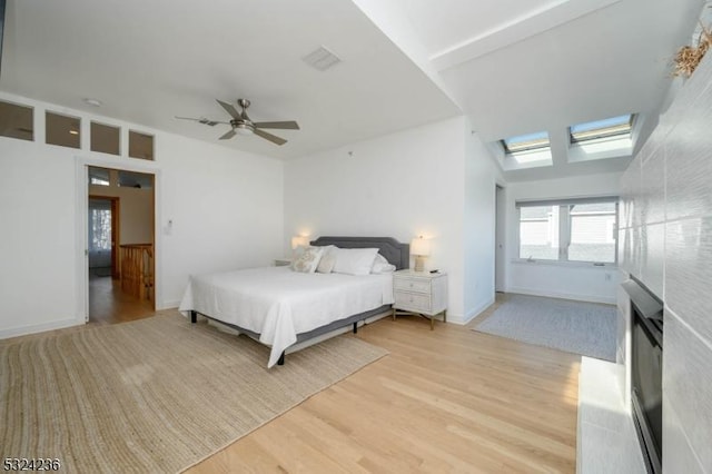 bedroom with visible vents, baseboards, ceiling fan, and light wood finished floors