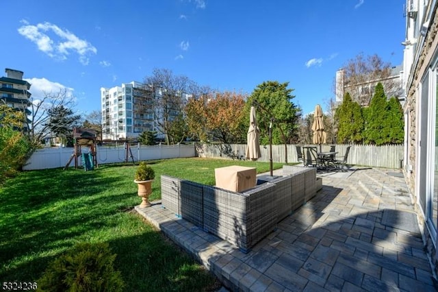 view of patio featuring an outdoor living space, outdoor dining area, a fenced backyard, and a playground