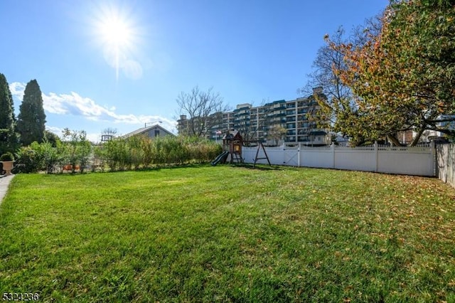 view of yard with playground community and fence