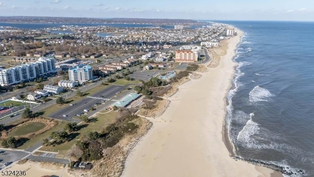 drone / aerial view featuring a city view, a view of the beach, and a water view