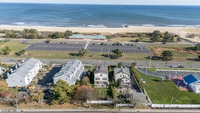 drone / aerial view featuring a beach view and a water view