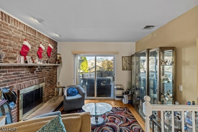 living room featuring light hardwood / wood-style floors and a brick fireplace