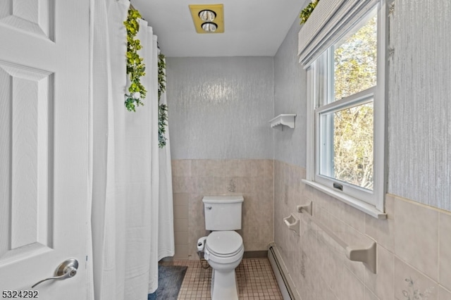 bathroom with tile patterned flooring, plenty of natural light, toilet, and tile walls