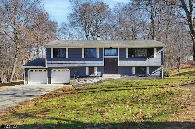 raised ranch featuring a garage and a front yard