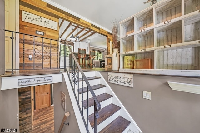 staircase featuring wood walls and hardwood / wood-style flooring