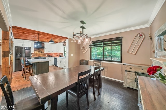 dining room featuring dark hardwood / wood-style floors, sink, and crown molding