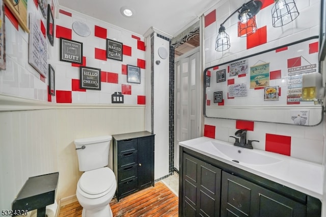 bathroom with vanity, hardwood / wood-style flooring, toilet, and backsplash