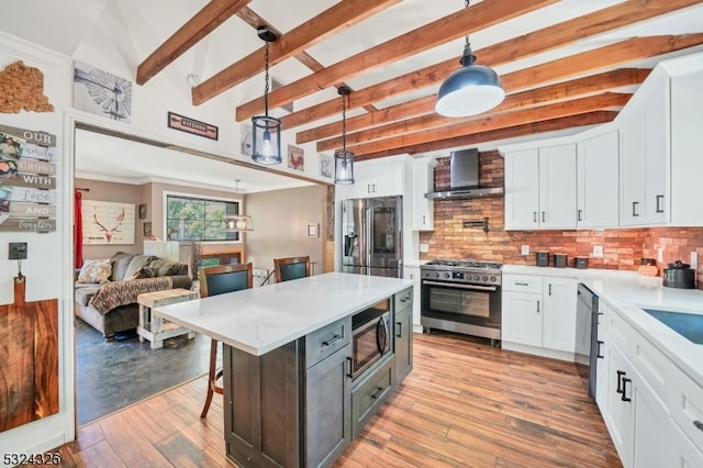 kitchen with stainless steel appliances, pendant lighting, wall chimney exhaust hood, backsplash, and white cabinetry