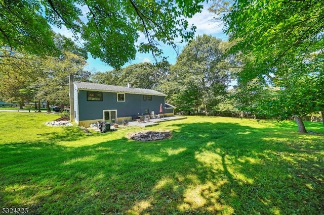 rear view of house with a lawn and a patio area