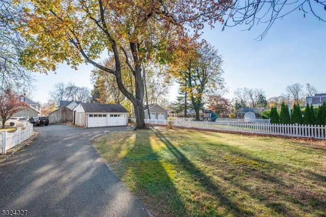 exterior space with a front lawn, a garage, and an outdoor structure