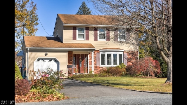 colonial home featuring a garage and a front yard