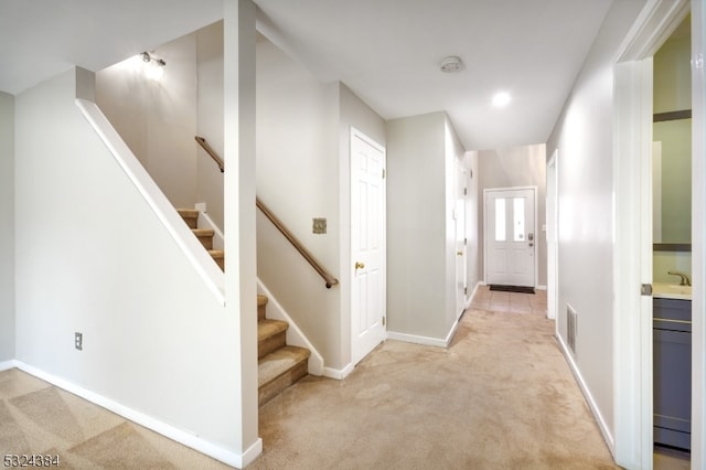 corridor with light colored carpet and sink