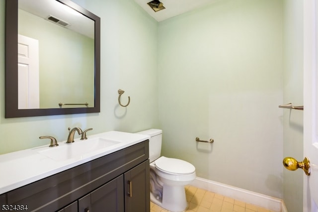 bathroom with tile patterned flooring, vanity, and toilet