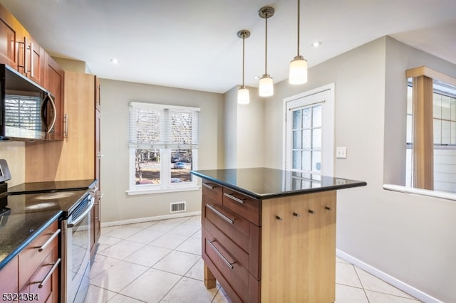 kitchen featuring a center island, light tile patterned floors, pendant lighting, and appliances with stainless steel finishes