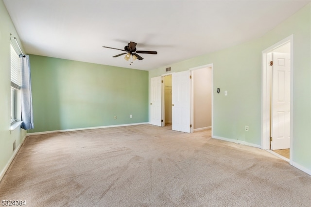 carpeted spare room featuring ceiling fan