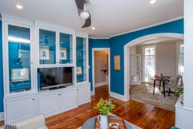 living room with crown molding, ceiling fan, and light wood-type flooring