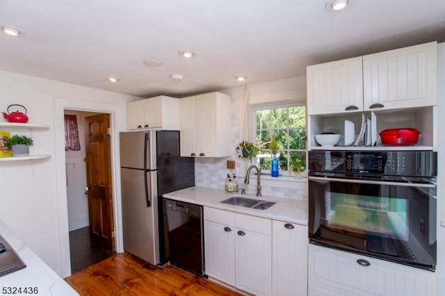 kitchen with decorative backsplash, dark hardwood / wood-style flooring, sink, black appliances, and white cabinetry