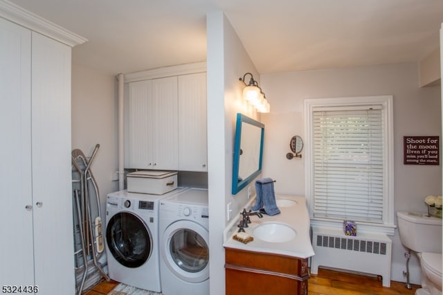 laundry area with washer and dryer, light hardwood / wood-style floors, radiator, and sink