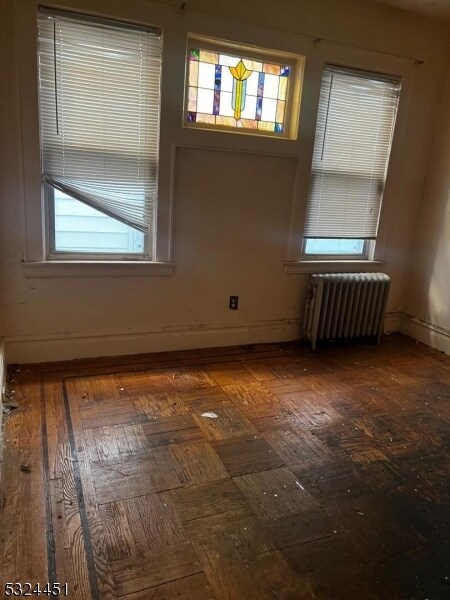 empty room with a healthy amount of sunlight and radiator heating unit