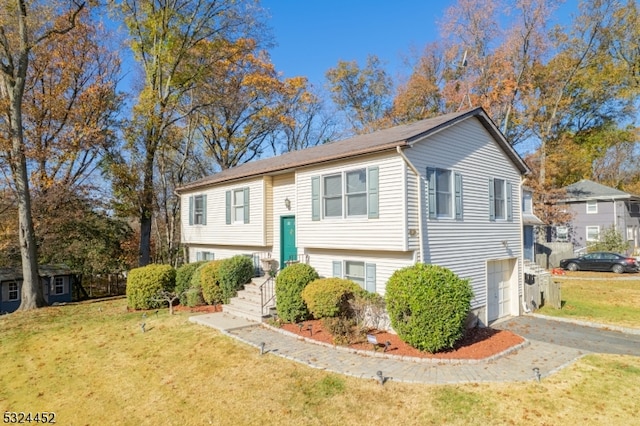 bi-level home featuring a garage and a front yard