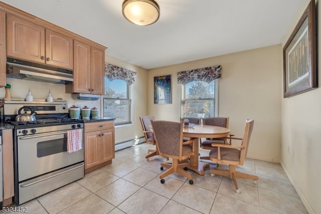 kitchen featuring baseboard heating, dark stone countertops, light tile patterned flooring, and stainless steel range oven