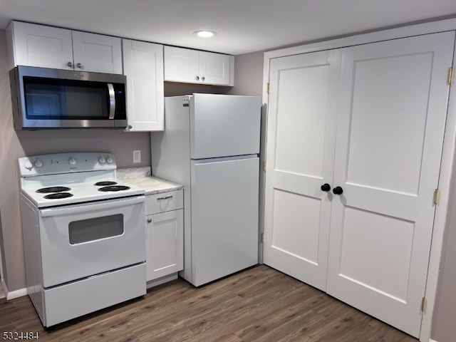 kitchen with white cabinetry, dark hardwood / wood-style flooring, and white appliances