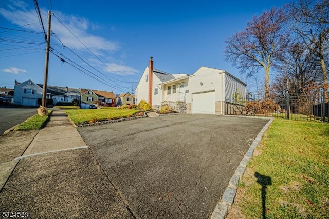 view of side of home featuring a garage and a lawn