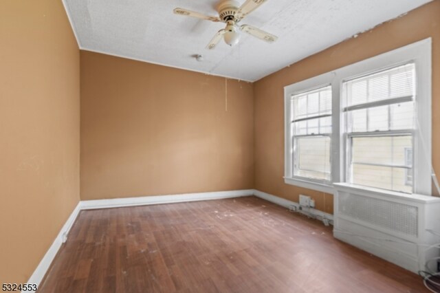 unfurnished room with ceiling fan and hardwood / wood-style floors