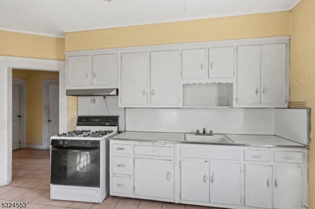 kitchen featuring white gas range, white cabinetry, sink, light tile patterned floors, and ornamental molding