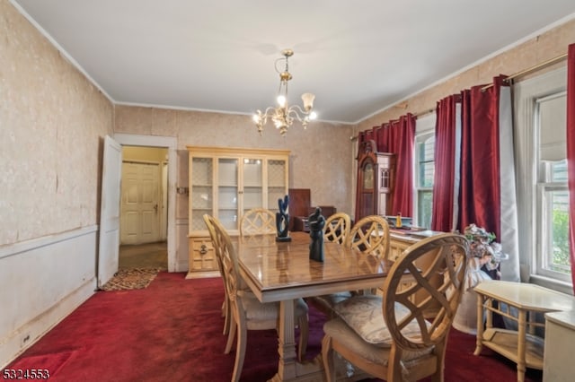 carpeted dining area with crown molding and a chandelier