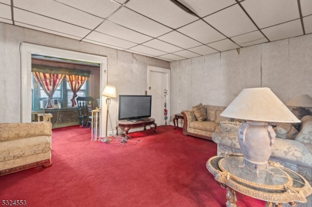 living room featuring carpet and a paneled ceiling